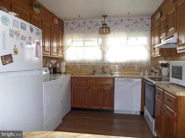 kitchen featuring white appliances, separate washer and dryer, a sink, light countertops, and under cabinet range hood