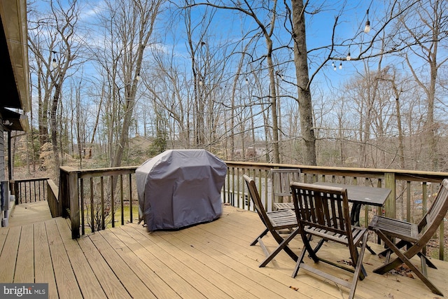 wooden deck featuring outdoor dining space and area for grilling