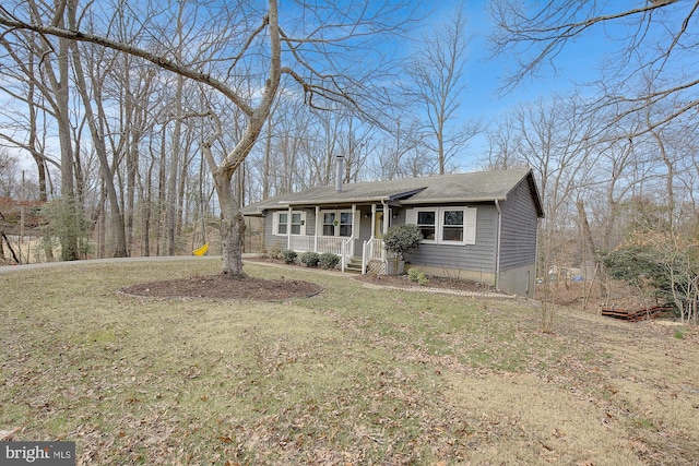 view of front of home featuring covered porch, a front lawn, and a chimney