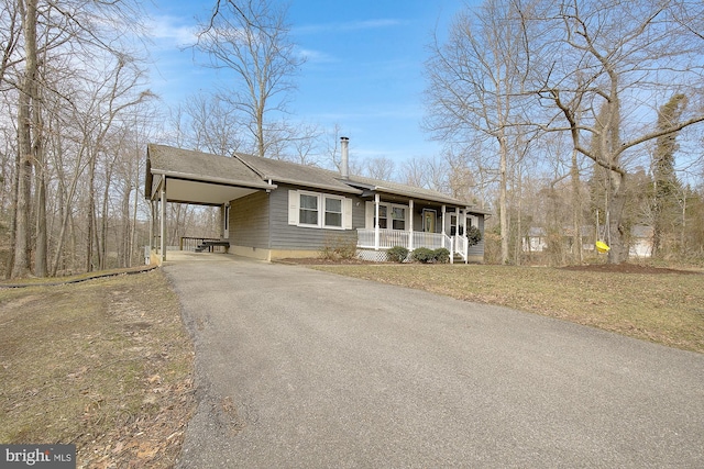 view of front facade with covered porch, a front lawn, aphalt driveway, and a carport