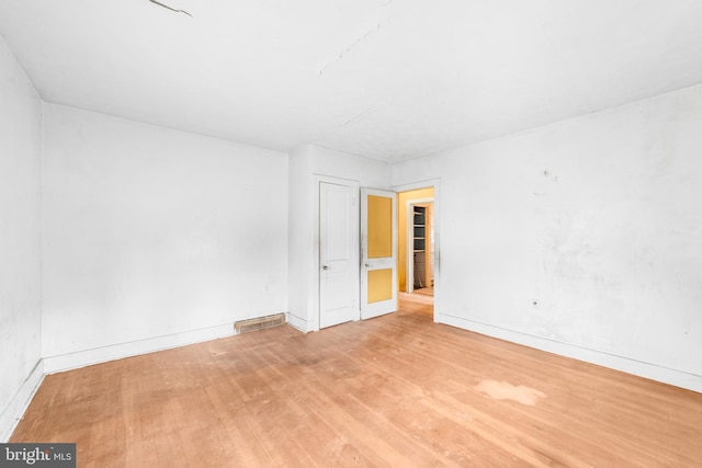 unfurnished room with light wood-style flooring and baseboards