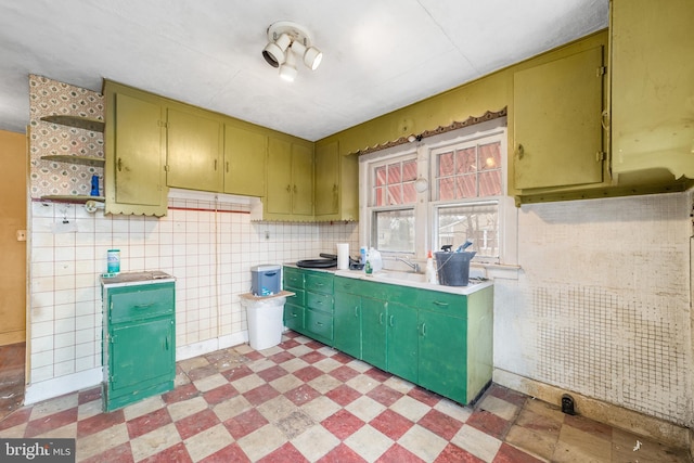 kitchen with green cabinets, open shelves, light floors, and light countertops