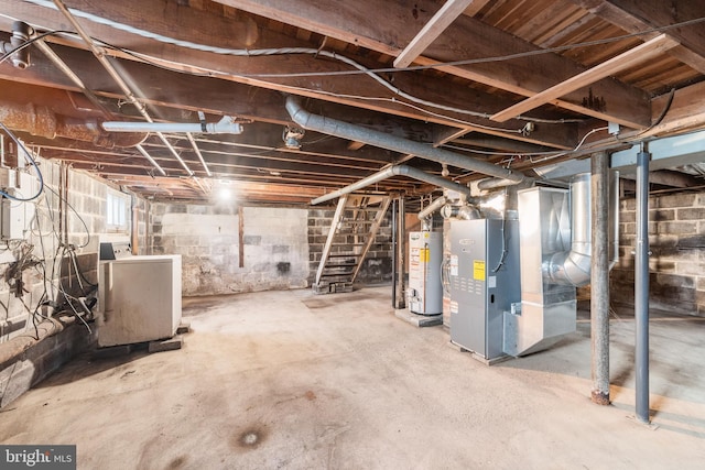 unfinished below grade area featuring water heater, stairway, and washer / dryer