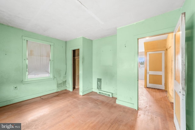 unfurnished bedroom featuring a closet, visible vents, and wood finished floors