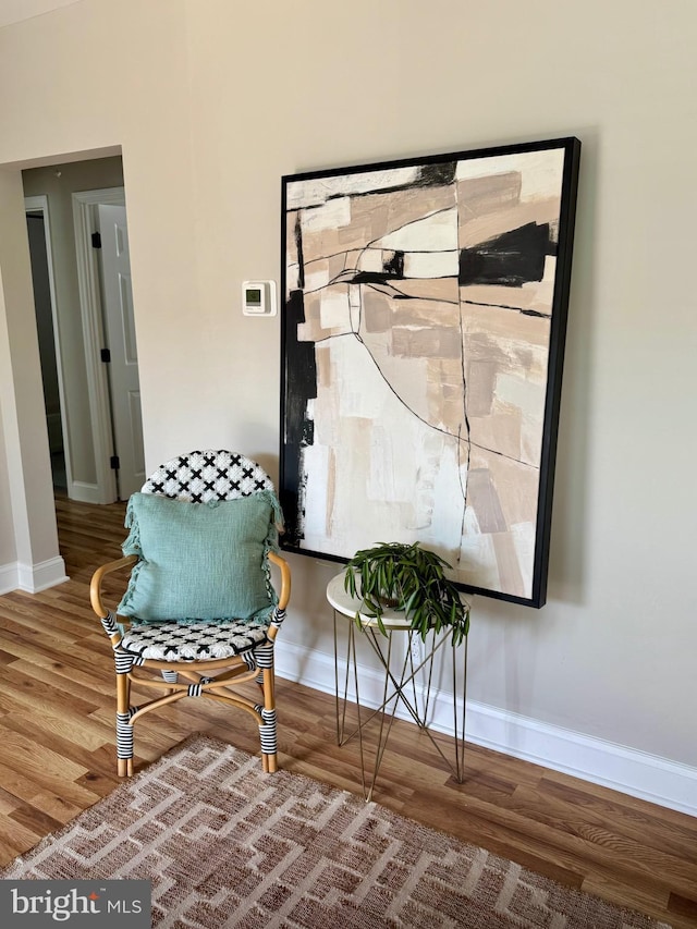 sitting room with baseboards and wood finished floors