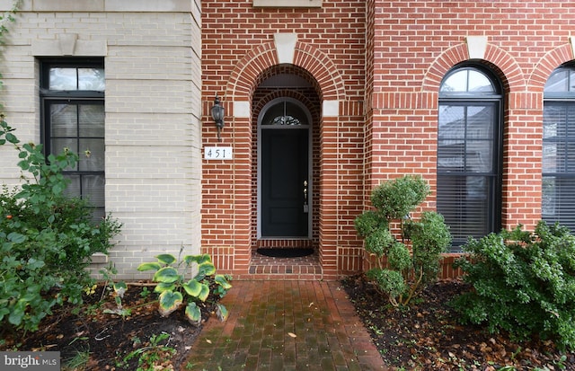 entrance to property featuring brick siding