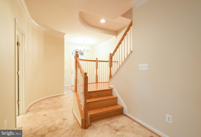 staircase featuring a notable chandelier, baseboards, and crown molding