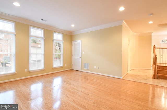 empty room featuring baseboards, visible vents, light wood-style flooring, crown molding, and recessed lighting