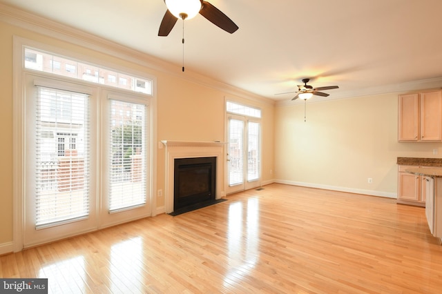 unfurnished living room with ornamental molding, a wealth of natural light, light wood-style floors, and a fireplace with flush hearth