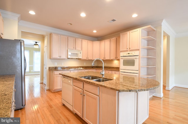 kitchen featuring light wood finished floors, open shelves, visible vents, a sink, and white appliances