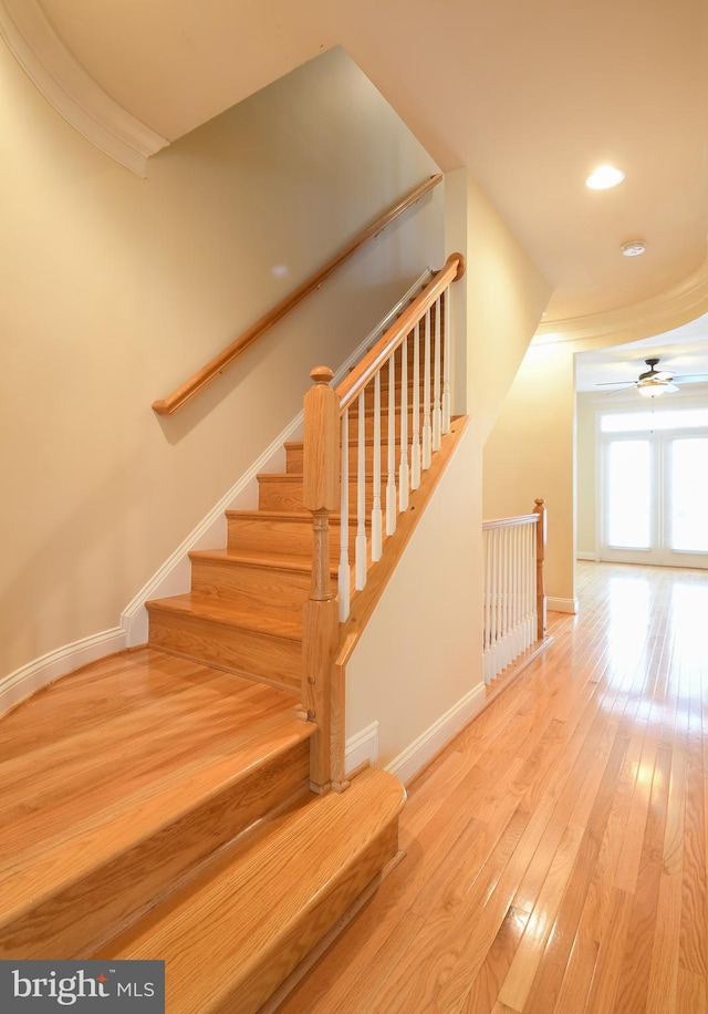 stairs featuring recessed lighting, hardwood / wood-style floors, ornamental molding, ceiling fan, and baseboards