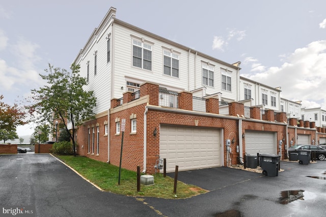 view of front of home with brick siding, driveway, and central air condition unit