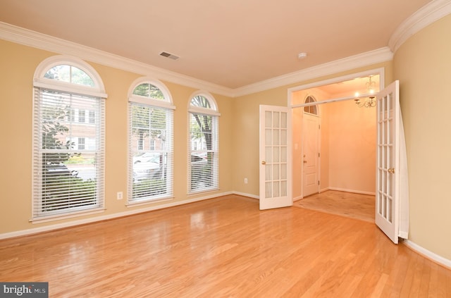 spare room featuring french doors, wood finished floors, visible vents, and crown molding