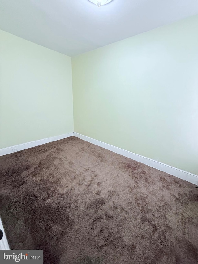 carpeted empty room featuring baseboards