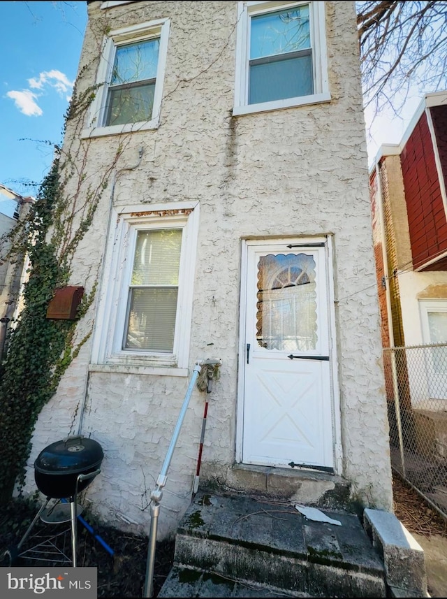 property entrance with stucco siding