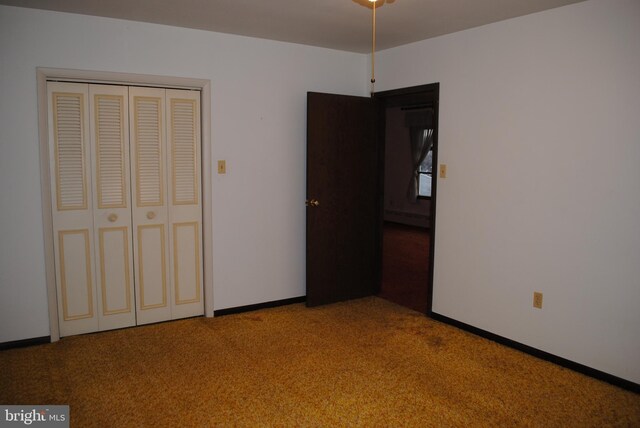 unfurnished bedroom featuring baseboards, carpet, a baseboard heating unit, and a closet