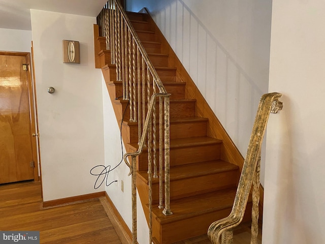 stairway featuring baseboards and wood finished floors