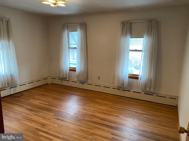 spare room with a wealth of natural light and hardwood / wood-style flooring