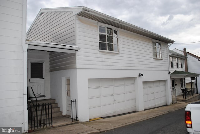 view of home's exterior with entry steps, an attached garage, and stucco siding