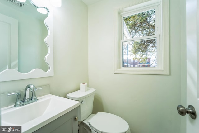 bathroom with visible vents, toilet, and vanity