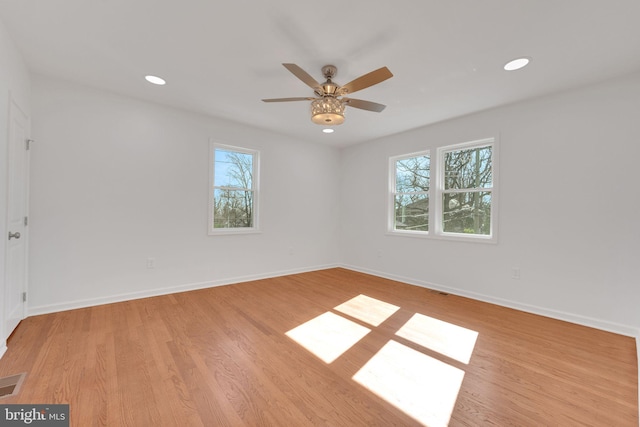 empty room with baseboards, plenty of natural light, and light wood-style floors