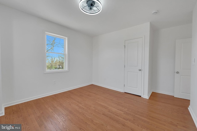 empty room with light wood-style flooring and baseboards