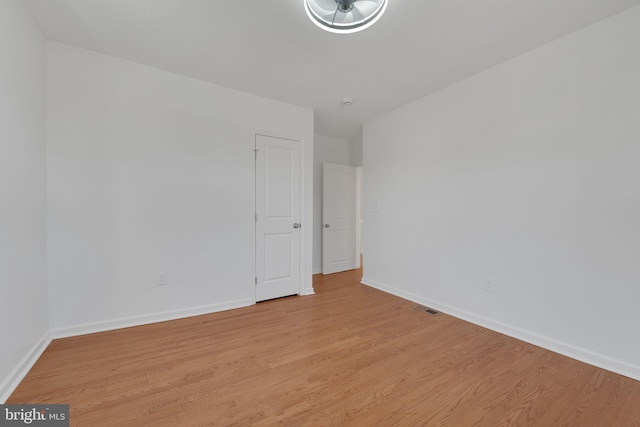 unfurnished room featuring visible vents, baseboards, and light wood-style floors