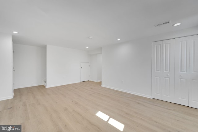 empty room featuring light wood finished floors, visible vents, and recessed lighting