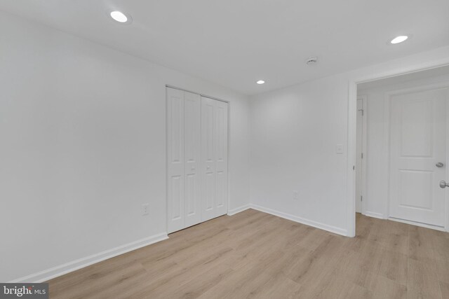 empty room with recessed lighting, light wood-style floors, and baseboards