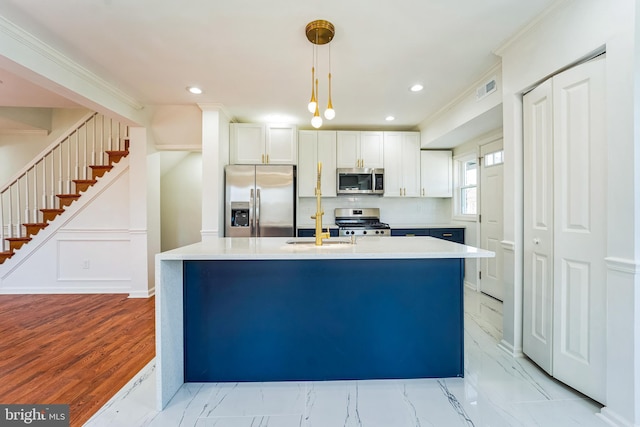 kitchen featuring visible vents, a kitchen island with sink, appliances with stainless steel finishes, crown molding, and decorative light fixtures