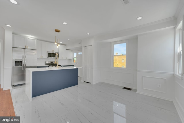 kitchen with visible vents, stainless steel appliances, light countertops, white cabinetry, and a center island