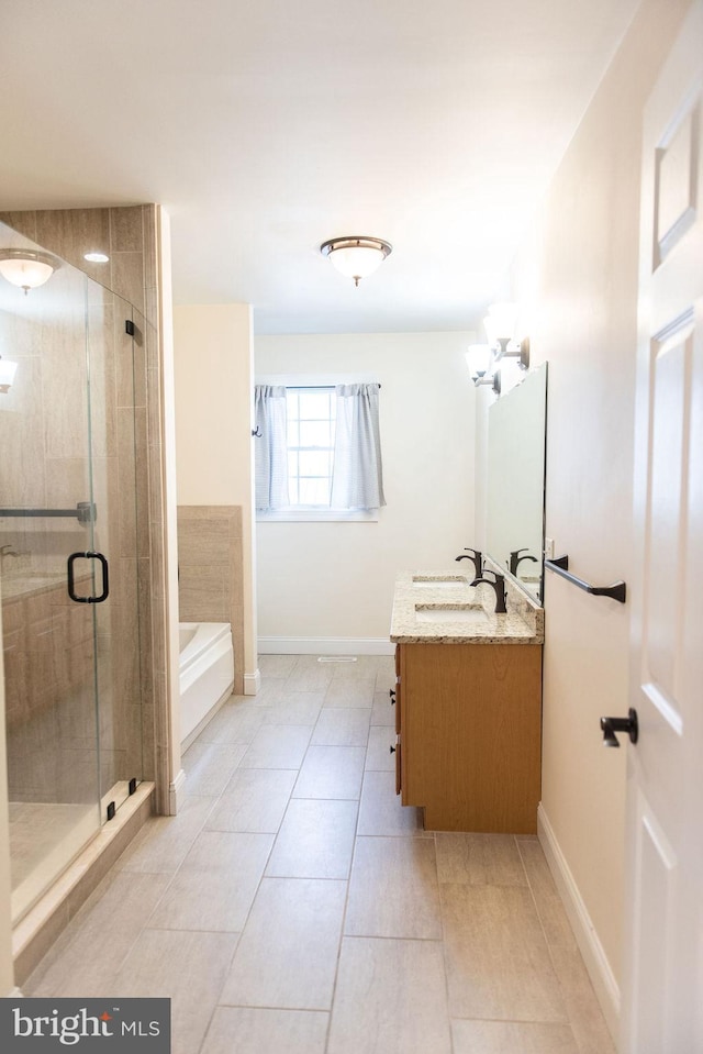 full bath with a garden tub, a stall shower, vanity, baseboards, and tile patterned floors