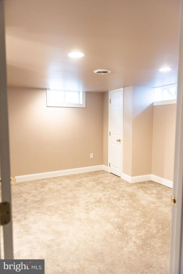 below grade area featuring carpet flooring, visible vents, and baseboards