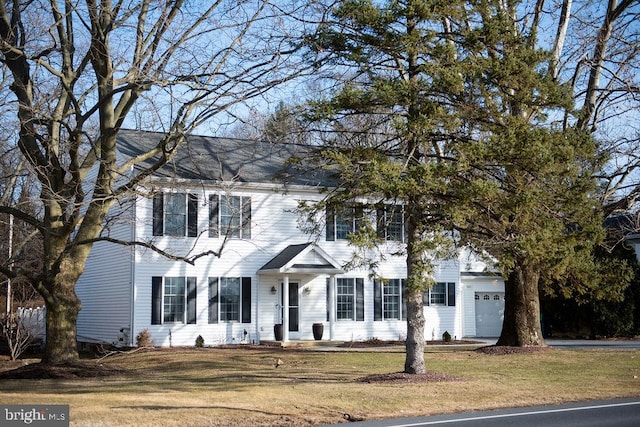 colonial-style house with a garage and a front yard