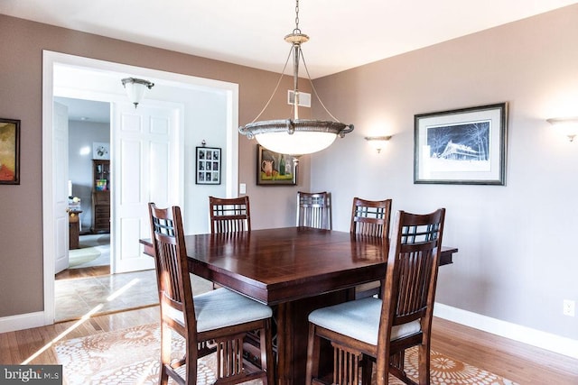 dining room with light wood-style floors, visible vents, and baseboards