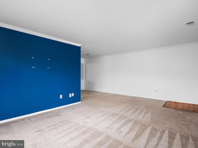 unfurnished room featuring carpet flooring, visible vents, and crown molding