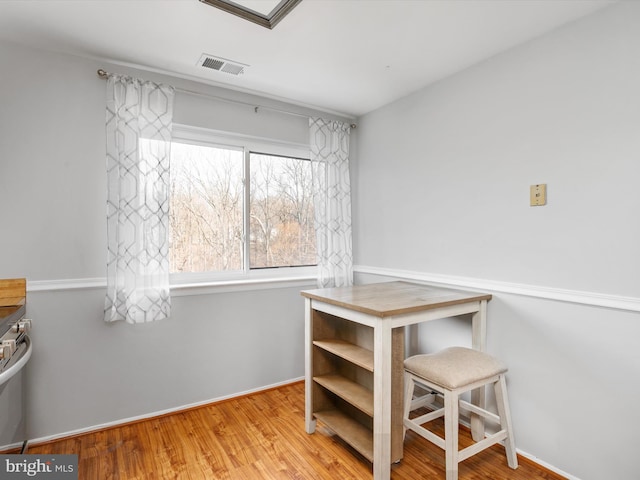 dining space featuring baseboards, visible vents, and wood finished floors