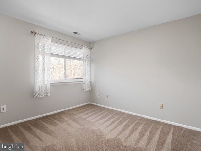 spare room with baseboards, visible vents, and carpet flooring