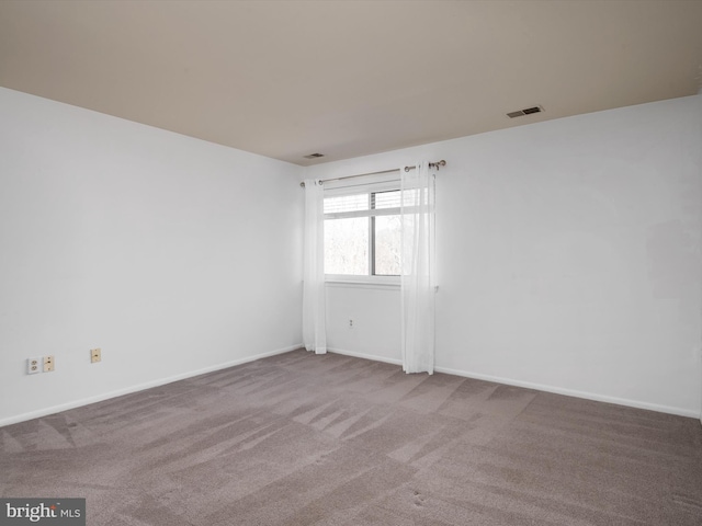 carpeted empty room featuring visible vents and baseboards