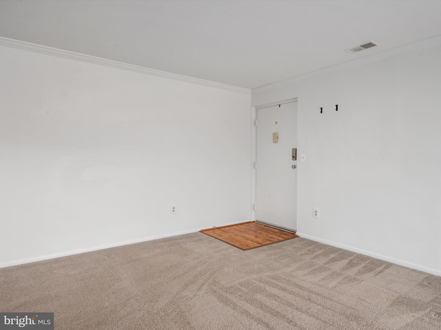 carpeted empty room featuring visible vents, crown molding, and baseboards