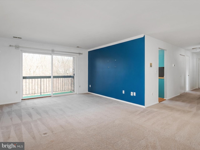 empty room with carpet floors, visible vents, and baseboards