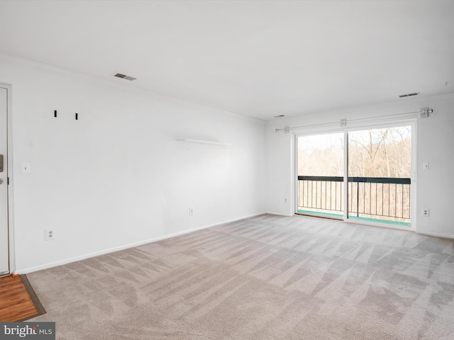 empty room with carpet flooring, visible vents, and baseboards