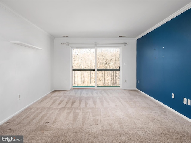 carpeted empty room featuring baseboards, visible vents, and crown molding