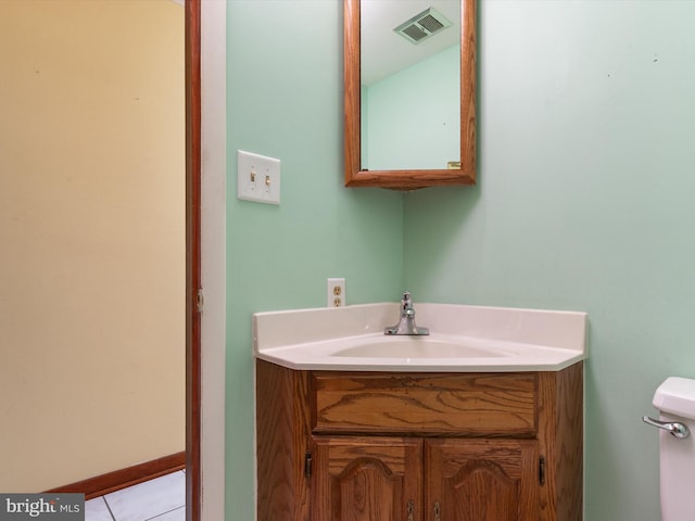 bathroom featuring visible vents, toilet, vanity, and baseboards