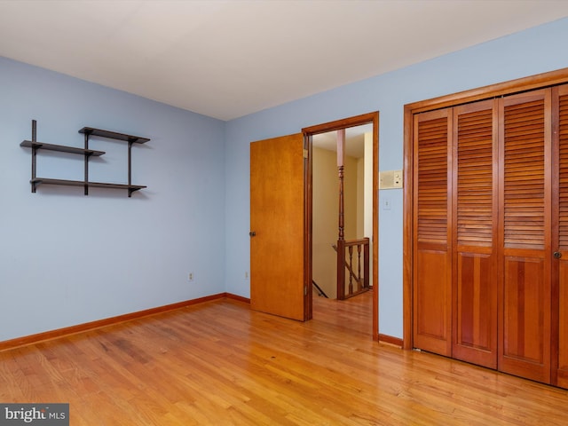 unfurnished bedroom featuring a closet, baseboards, and light wood-style floors