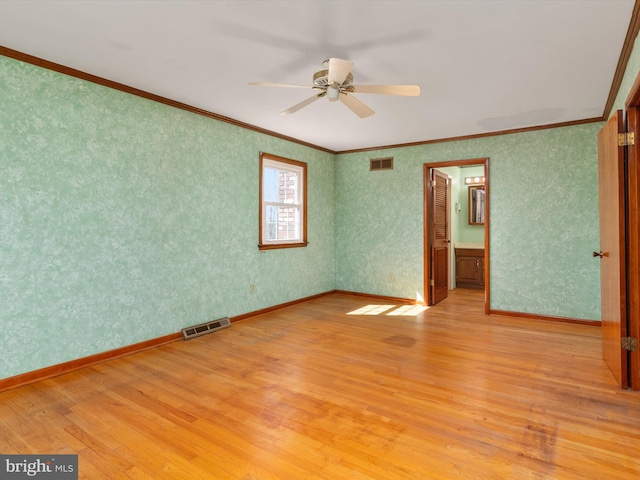 unfurnished room featuring wallpapered walls, light wood-style floors, and visible vents