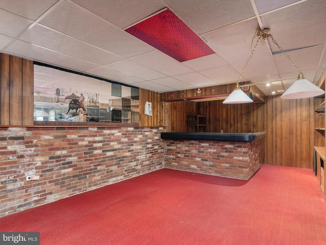 bar with a drop ceiling, wood walls, and carpet