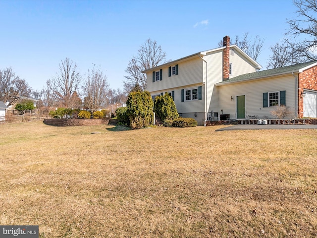 rear view of house with a yard and a chimney