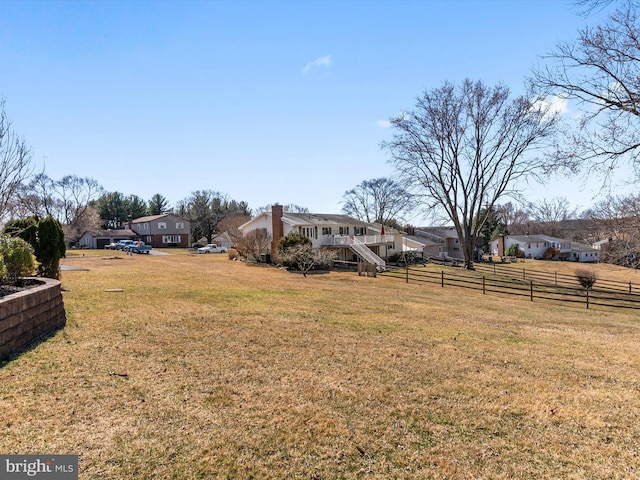 view of yard with stairway, a residential view, and fence