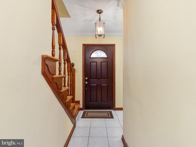 foyer entrance with light tile patterned flooring, stairway, crown molding, and baseboards